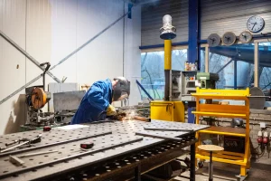 man welding in a steel door manufacturing factory